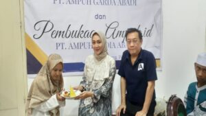 Ustadzah Anggita menyerahkan potongan tumpeng kepada Komisaris PT Ampuh Garda Abadi, Mega Permata Sari.
