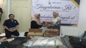 Komisaris PT Ampuh Garda Abadi Mega Permata Sari secara simbolis menyerahkan bantuan sembako untuk anak-anak panti yang diterima oleh Ustadzah Anggita.