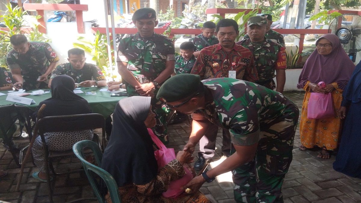 Danton Yonif 400/BR, Letkol Inf M Zainollah berdialog dengan seorang ibu yang menjadi salah satu penerima bansos.