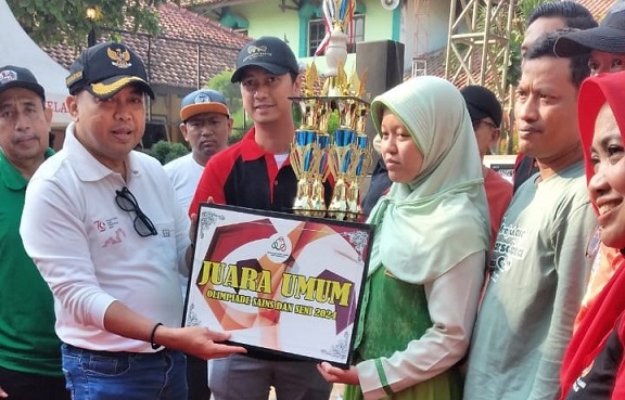 Plt Bupati Jepara, Edy Supriyanta (kiri) menyerahkan penghargaan dan Piala Bergilir Bupati kepada perwakilan siswa Sekolah Dasar Unggulan Terpadu (SDUT) Bumi Kartini Jepara yang meraih juara umum dalam Lomba Harlah Ke-60 SMPN 1 Pecangaan.