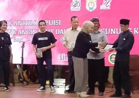 Bupati Kendal Dyah Kartika Permanasari menyerahkan buku antologi puisi tentang Kendal secara simbolis kepada sejumlah seniman setempat di Pendopo Tumenggung Bahurekso Kendal, Sabtu malam (26/7/2025).